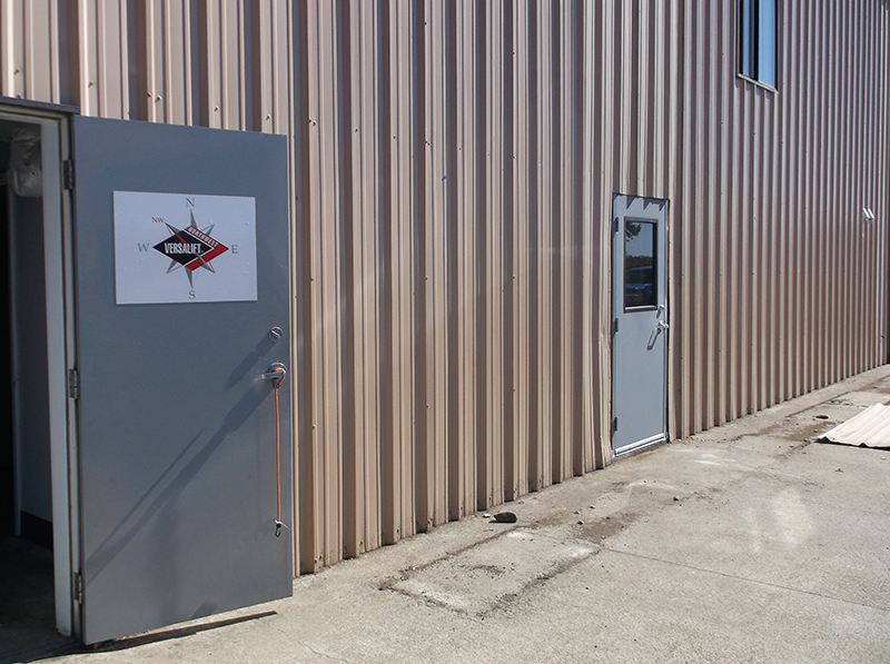 Door open on side of metal paneling industrial building at Brooklane building