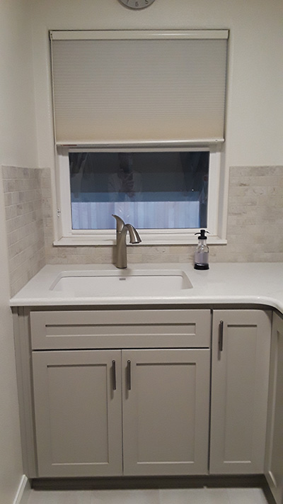 Straigt on view of sink, window, and cabinets