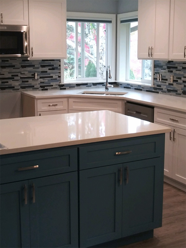 White and blue cabinetry, blue and white tiling, and white marble countertops