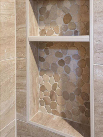 Renovated shower with pebble stones in the shelving