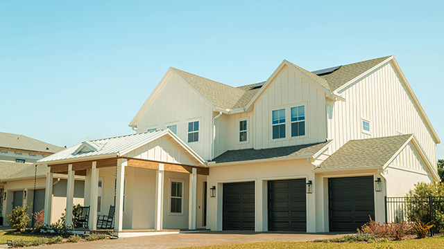 a large white house with two garages on the front of it